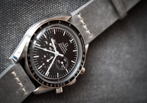 Omega Speedmaster Professional Moonwatch ref. 311.30.42.30.01.005 in steel with black dial, black tachymeter bezel and Hesalite crystal, on a grey leather strap