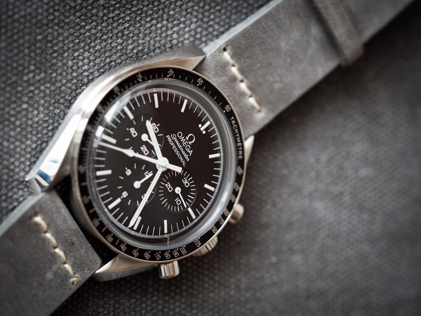 Omega Speedmaster Professional Moonwatch ref. 311.30.42.30.01.005 in steel with black dial, black tachymeter bezel and Hesalite crystal, on a grey leather strap